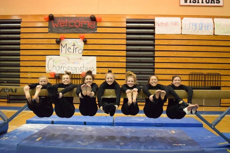 (Photo courtesy of Philip Coleman)(From left to right) Clara Yardley (12), Lily Godon (12), Amirah Karam (10), Hannah Hudson (12), Emma Combes (11), Mari Huff (10) and Bella Steenstra (12) pose on a beam after their metro championship victory.