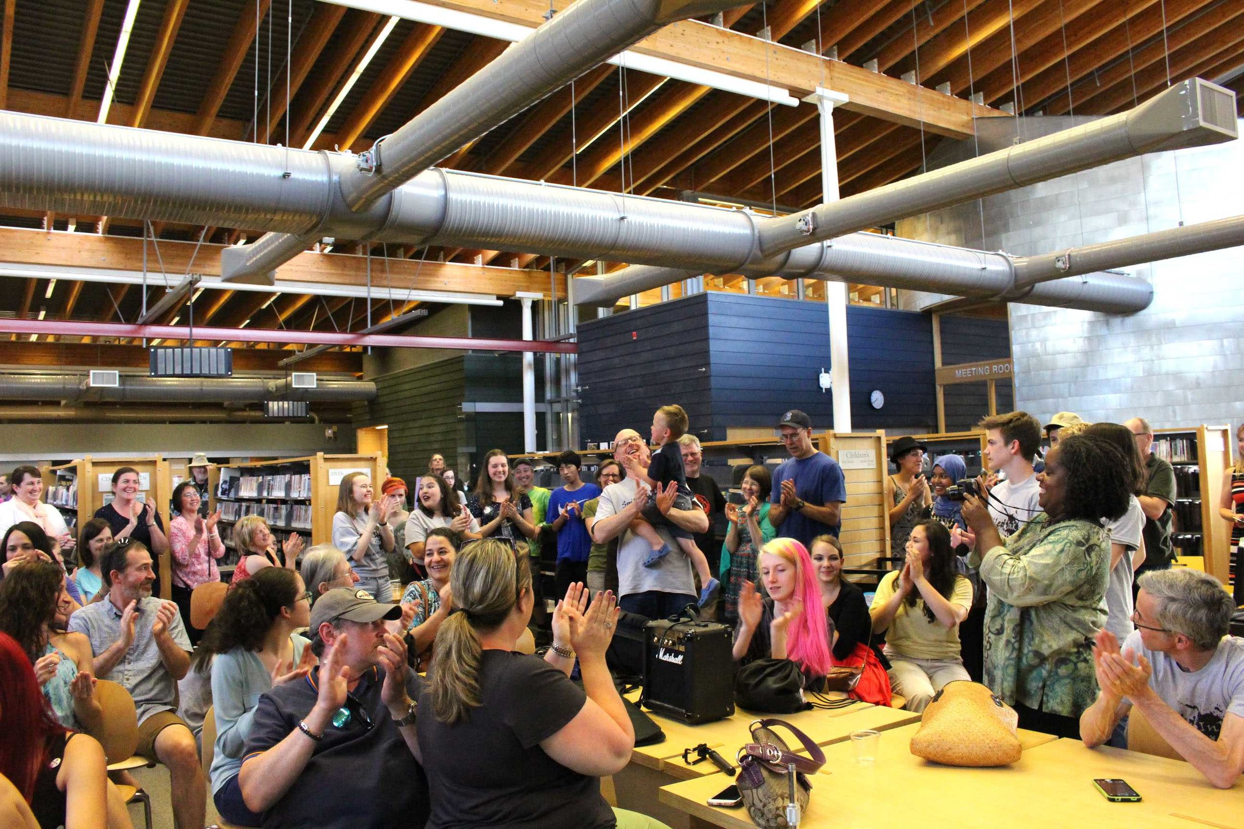 Even though it was his son’s birthday, art teacher Matt Harkleroad made it to Spilled Ink Art and Literature Night. Here, the crowd applauds after singing happy birthday to the newly three-year-old boy.