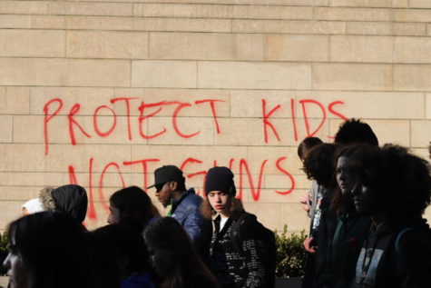 Students protest in front of a spray painted message reading protect kids not guns at Seattle City Hall after the Ingraham shooting.