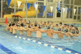 In a spirited camaraderie of their first meet, the boys swim team unites through a powerful bond and their team chant.