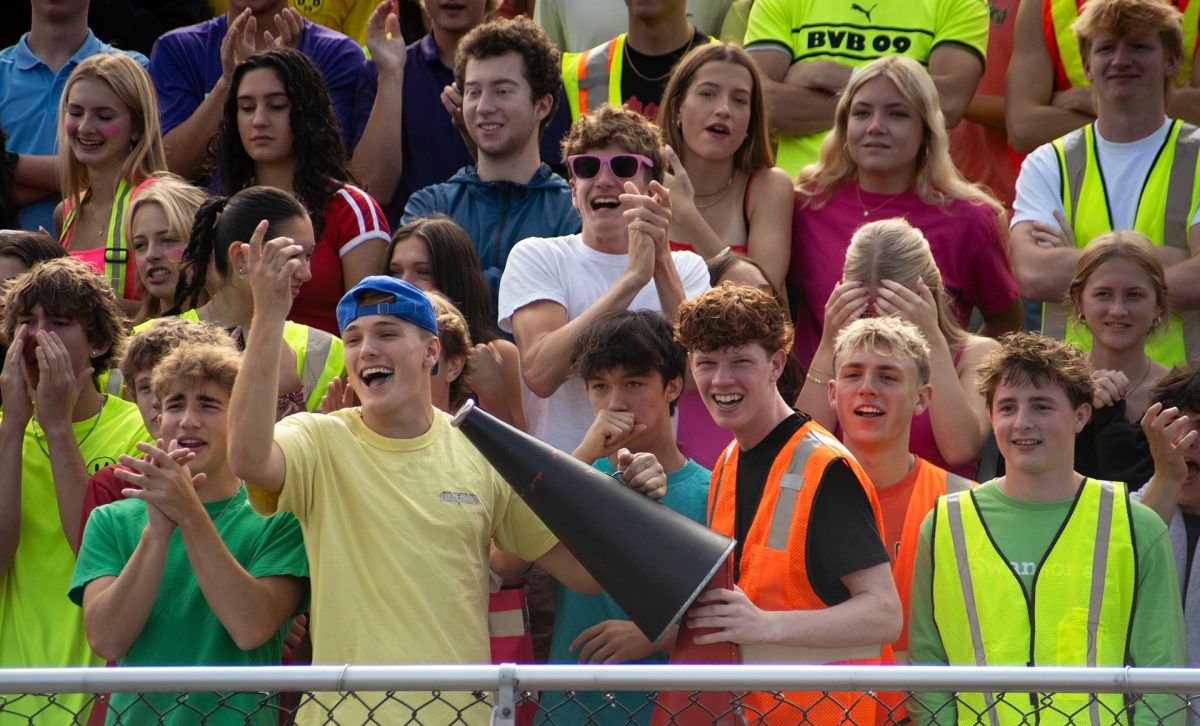 Students cheer for the football team decked out in neon clothes for the homecoming theme. The beavers lost to Roosevelt 10-3.